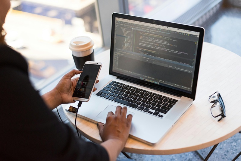 Freelance coder working on a laptop with code on the screen, symbolizing remote work opportunities and career growth.