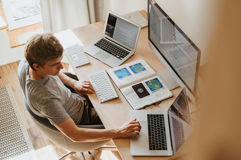 A freelance coder working on a laptop, exploring coding gigs on an online job platform