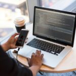 A person coding on a laptop, representing the decision-making process of whether to attend a coding boot camp.