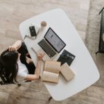 Freelancer multitasking efficiently with a laptop, planner, and coffee, managing multiple projects productively.