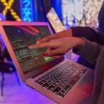 Young coder staying motivated while learning to program at a computer with bright visuals and code on screen.