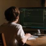 Software developer coding at a desktop workstation, representing today's coding job market and remote work.